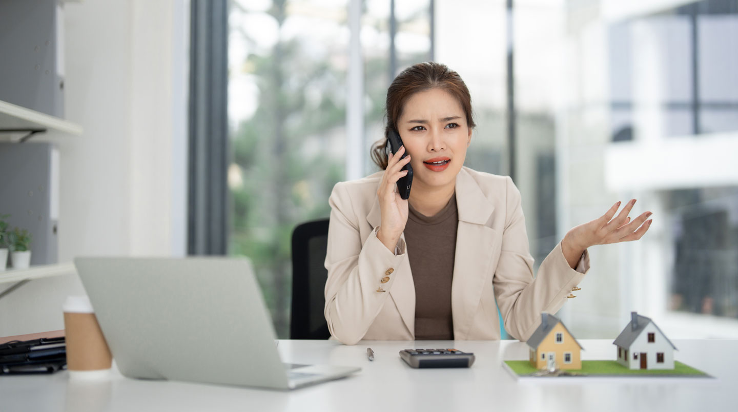 Couple assis côte à côte devant un écran d'ordinateur, affichant une expression de confusion et de fatigue face à la multiplicité des annonces immobilières