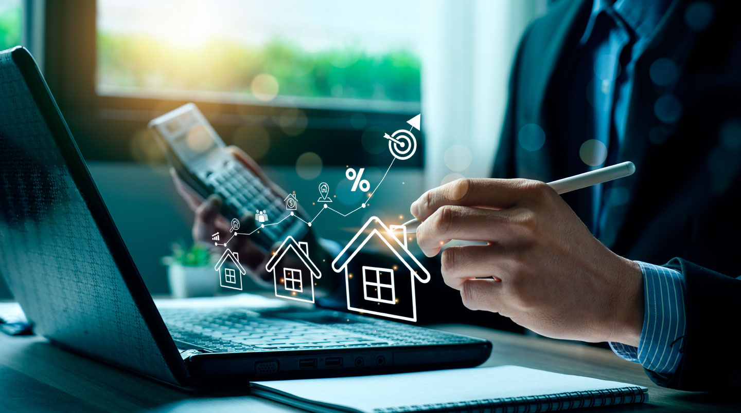 Photographie en gros plan d'une main tenant un smartphone affichant une application extranet immobilier avec trois graphiques ascendants verts, arrière-plan lumineux flou.